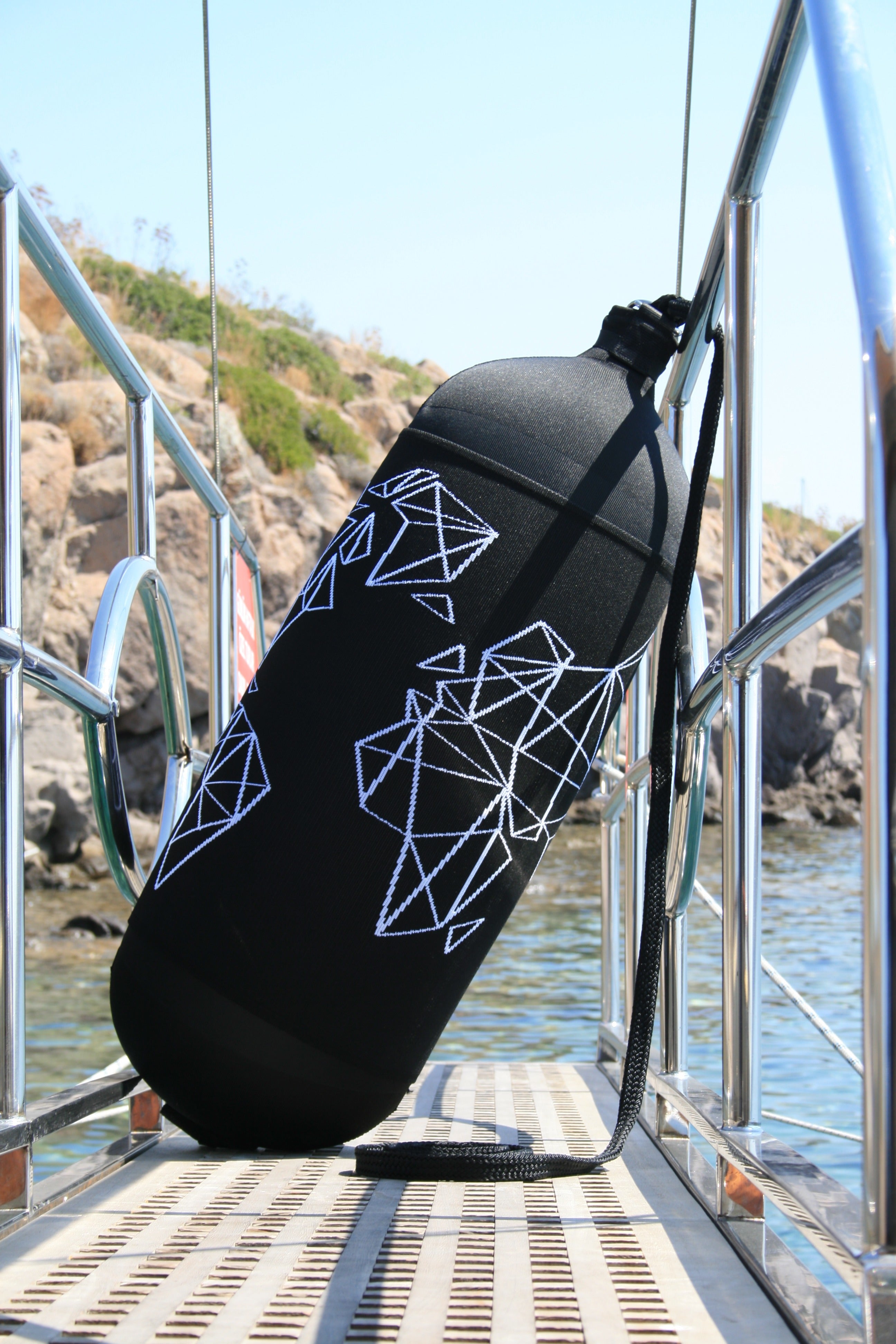 Custom designed fender cover and boat fender on a yacht boarding ladder