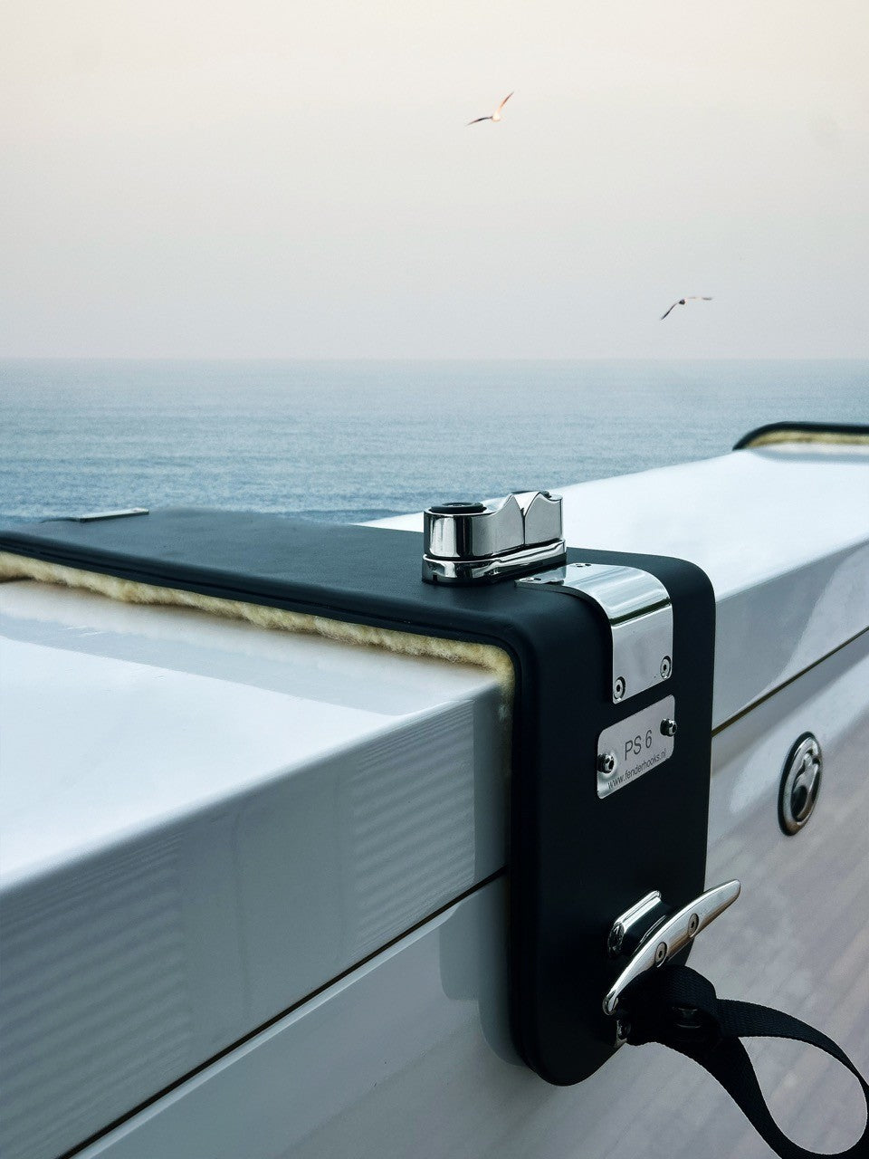 Close-up of a yacht's fenderhook with a scenic ocean background